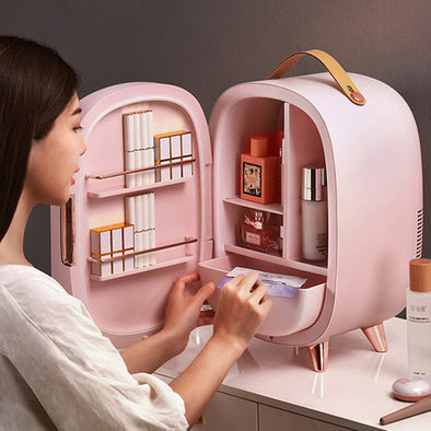 Person interacting with a pink cosmetic organizer filled with products on a table.