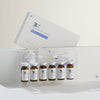 Set of medical vials with a branded box on a white background